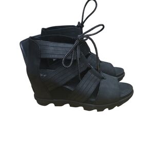 Sorel Joanie II Lace wedge sandals in black, featuring a strappy lace-up design.